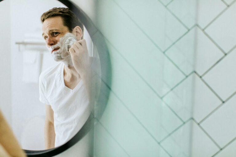 Man shaving bathroom mirror