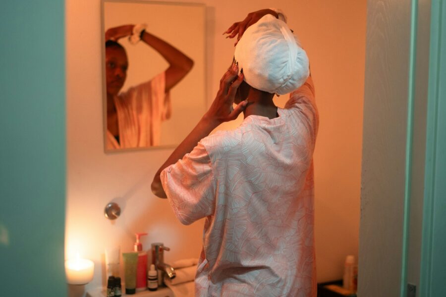 Woman brushing wet hair bathroom mirror