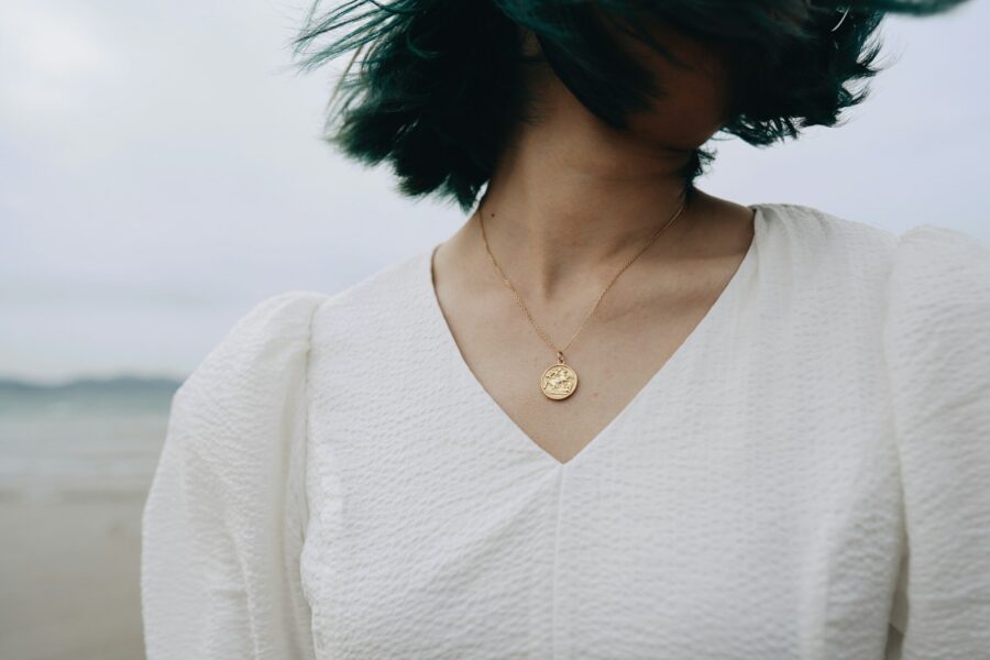Layered gold necklaces white shirt close