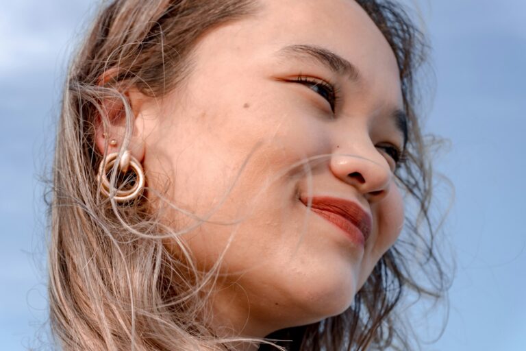 Woman wearing simple hoop earrings layered necklaces